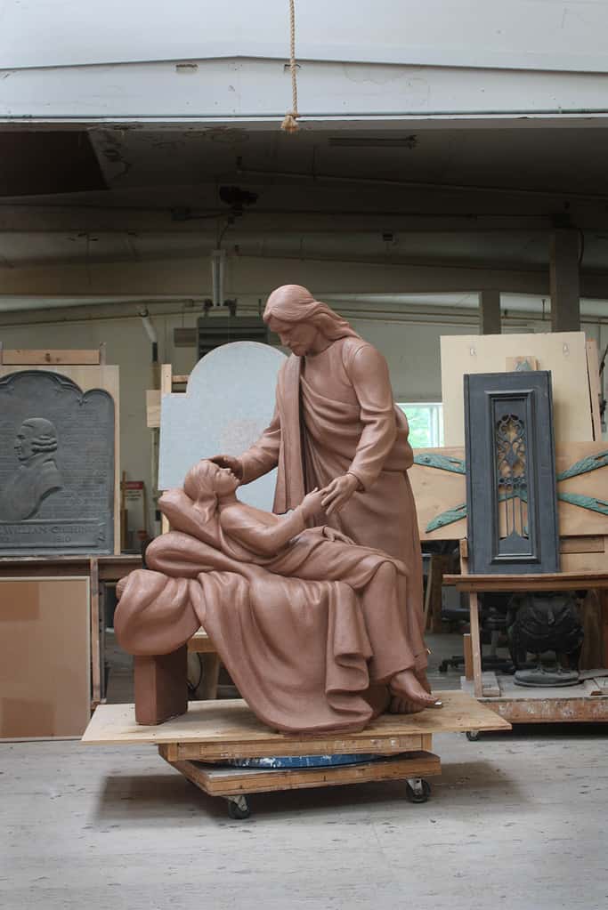 Christ the Healer Clay Model IMG_4257 clay model of sculpture of Jesus Christ figure leaning over sick child on bed in sculpture studio
