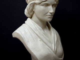 white plaster bust of female, namely Mary Wollstonecraft, against dark gray background