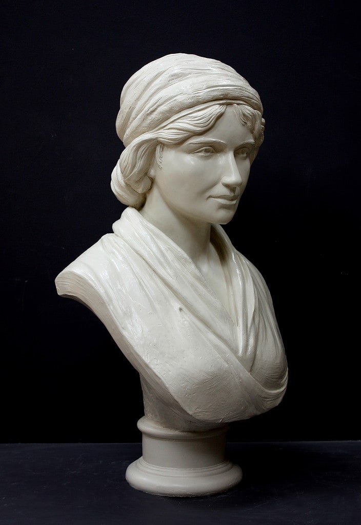 white plaster bust of female, namely Mary Wollstonecraft, against dark gray background