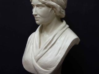 white plaster bust of female, namely Mary Wollstonecraft, against dark gray background