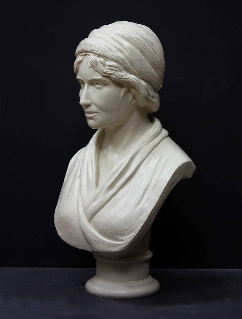 white plaster bust of female, namely Mary Wollstonecraft, against dark gray background