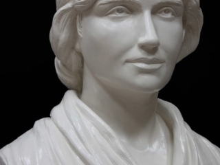 detail of white plaster bust of female, namely Mary Wollstonecraft, against dark gray background